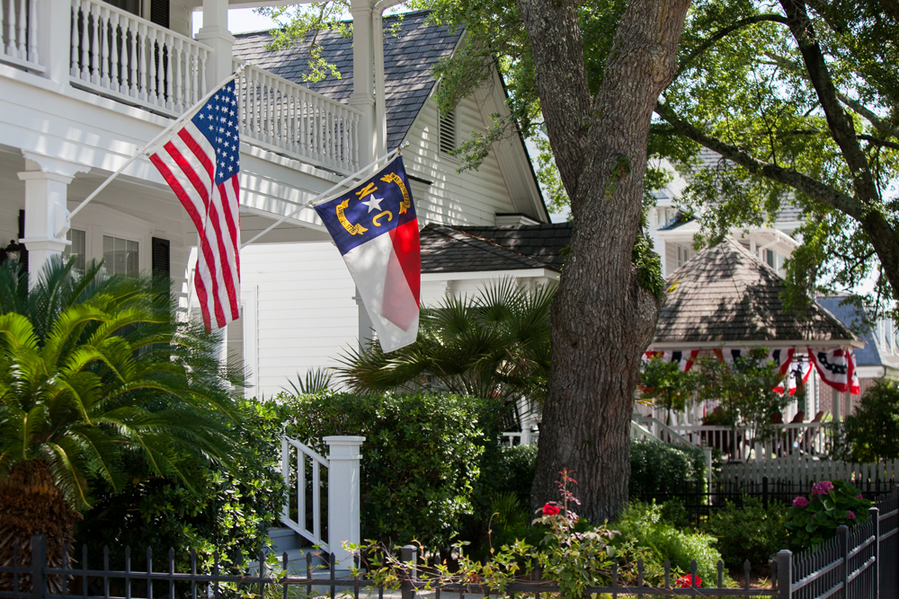 Front porch in North Carolina displaying both the United States and North Carolina state flags.